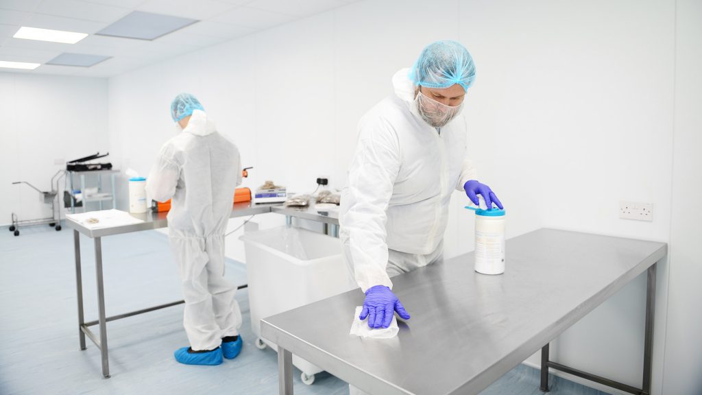 Photo of two people cleaning surfaces in a cleanroom - Integrity Cleanroom