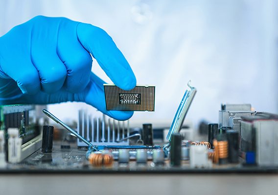 Scientist hand holding computer microchip - Integrity Cleanroom